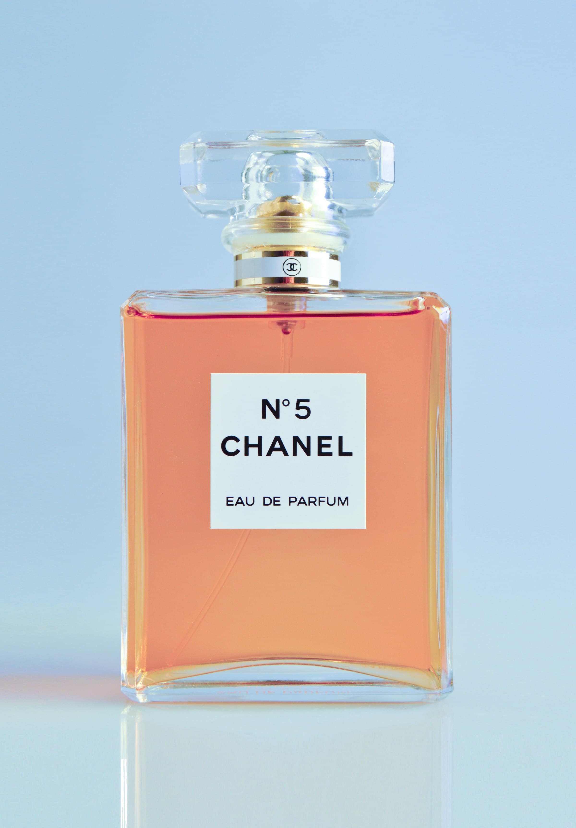A cologne bottle resting on a dark surface with soft light